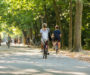 A girl and boy biking in the park.